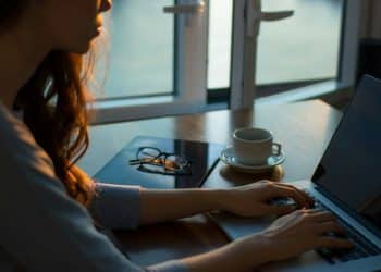 woman sitting beside table using laptop